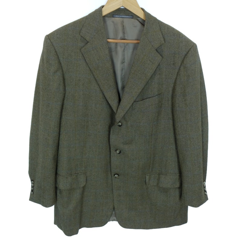 May include: A brown tweed blazer with a three-button closure and flap pockets.