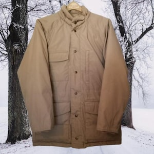 May include: A tan quilted jacket with a high collar, multiple pockets, and a button closure.