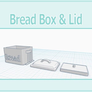 Op de afbeelding: Een witte broodtrommel met het woord "Brot" erop gedrukt. De trommel is open en het deksel is eraf. Het deksel heeft een handvat en een klein knopje bovenop. De trommel en het deksel staan op een witte rasterachtergrond.