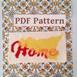 May include: A crochet pattern for a "Home" sign with a yellow and orange gradient. The pattern is displayed on a white background with a tiled pattern.
