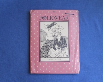 May include: A pink sewing pattern booklet with a black and white illustration of two women wearing traditional clothing. The title of the pattern is "Folkwear" and the text "Nepali Blouse" is printed below the illustration.