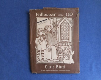 May include: Folkwear Ethnic Patterns sewing pattern number 110, titled "Little Rittel". The pattern features a black and white illustration of two children wearing traditional clothing, standing in front of a building with a stained glass window.
