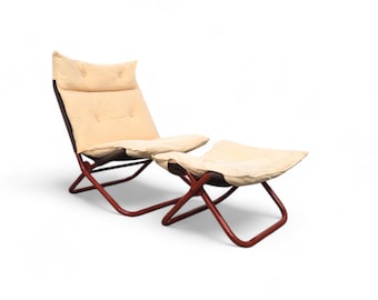 May include: A beige upholstered lounge chair and ottoman with a red metal frame. The chair and ottoman are both foldable.