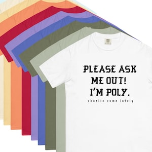 May include: A white t-shirt with the text "PLEASE ASK ME OUT! I'M POLY." in black, with "charlie come lately" below. The image shows the shirt in various colors, including yellow, orange, red, and blue.