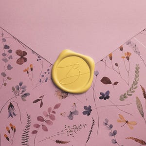 May include: A light pink envelope with a floral pattern featuring butterflies, flowers, and foliage. A yellow wax seal with a script initial is centered on the envelope, creating a delicate and artistic design.