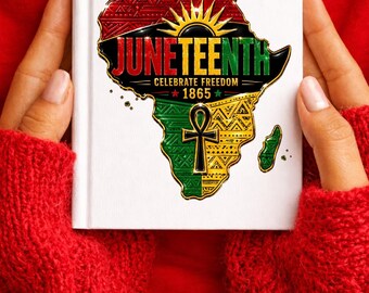 May include: A white hardcover book featuring a graphic of the African continent in red, black, green, and yellow. The text reads JUNETEENTH CELEBRATE FREEDOM 1865, accompanied by a sunburst icon and an ankh symbol with intricate geometric patterns.