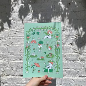 May include: A green and white print featuring a whimsical illustration of figures in a garden setting. The figures are surrounded by flowers, leaves, and vines. The print is on a light green background.