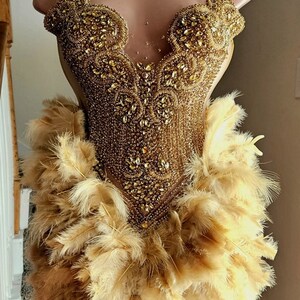 Vestido de plumas con corpiño de diamantes de imitación dorados