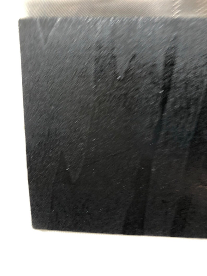 May include: A close-up of a black, textured surface. The surface appears to be made of a material like leather or suede.