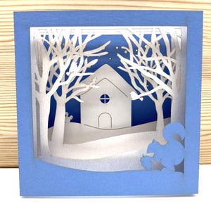 Carte Pop-Up Noël - Paysage Hivernal 3D avec Écureuil et Cabane sous la Neige