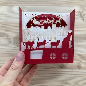 Carte Pop-up 3D de Vœux de Noel : Père Noël Survolant une Ville avec Chatons