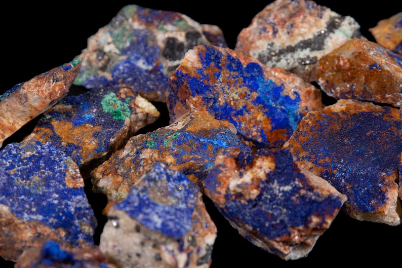 May include: Azurite and malachite rough stones in various sizes and shapes. The stones are a mix of blue, green, brown, and white.
