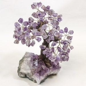 May include: Amethyst crystal tree with a purple and white base. The tree is made of wire and amethyst crystals.