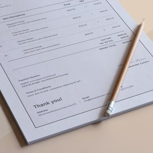 May include: A white invoice with a handwritten signature at the bottom. The invoice lists various design services with prices and quantities. The total amount is $8500.00. The invoice also includes contact information for the business, including an email address and phone number.