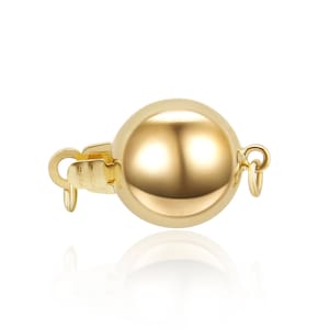 Può includere: Un fermaglio a sfera dorato con un'apertura a cerniera. Il fermaglio è progettato per essere utilizzato come chiusura per collane o braccialetti.