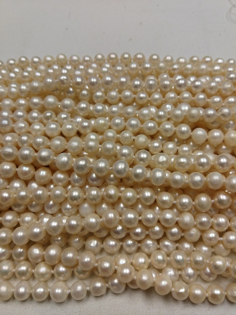 Puede incluir: Una hebra de perlas de agua dulce blancas. Las perlas son redondas y lisas, y est&aacute;n enhebradas en un hilo blanco.