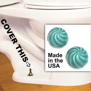 Puede incluir: Dos bolas de limpieza para inodoro de color azul turquesa con un diseño de espiral. El texto "Made in the USA" está impreso debajo de las bolas.