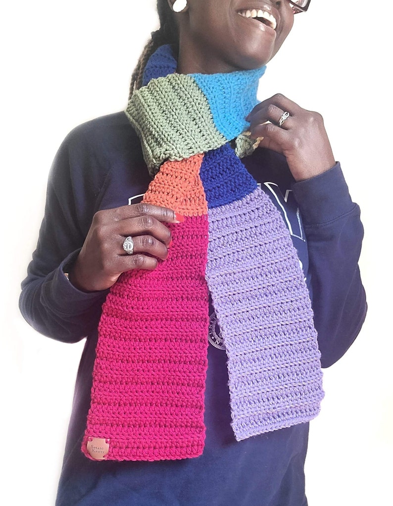 Model wearing rainbow scarf which is a long scarf.
