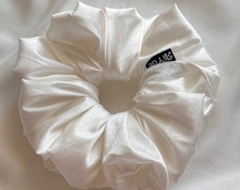 May include: White satin scrunchie with a black "Style" label.