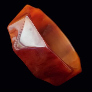 May include: A red and orange plastic bangle bracelet with a faceted design.