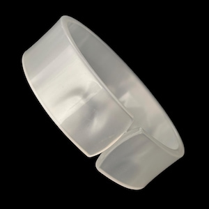May include: A translucent white cuff bracelet with a rectangular shape. The bracelet has a gap, and the edges are slightly rounded. The background is solid black.