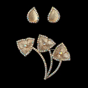 Horizontal front view of 1960s vintage iridescent rhinestone and gold tone floral brooch and clip on earring jewelry set.