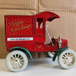 May include: Red toy delivery truck with a white and red polka dot design and the words "Happy Holidays" and "We value you". The truck has green wheels and a gold 1993 inscription.