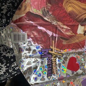Puede incluir: Un globo de papel de aluminio plateado metalizado con un gr&aacute;fico de Hannah Montana con chaqueta roja y pelo rubio. La superficie est&aacute; decorada con corazones hologr&aacute;ficos e incluye el texto Hannah Montana, un logo de Disney y un c&oacute;digo de barras n.&ordm; 16804.