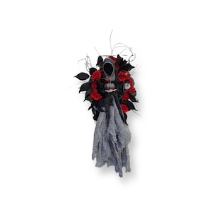 Scary Halloween ghost wreath for front door with spooky pumpkin, blood red flowers and frightening black leaves on oval twig wreath frame.