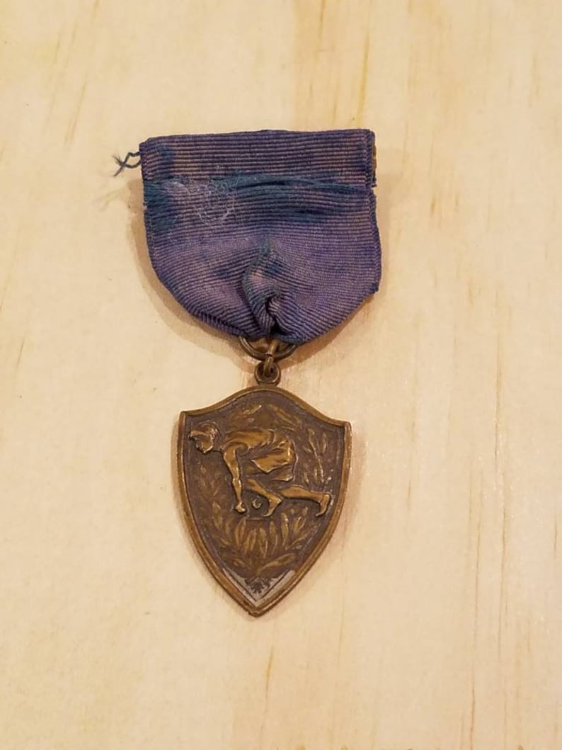 Gold color Vintage track and field medal pin intact blue ribbon Antique sports medal pin with blue ribbon.