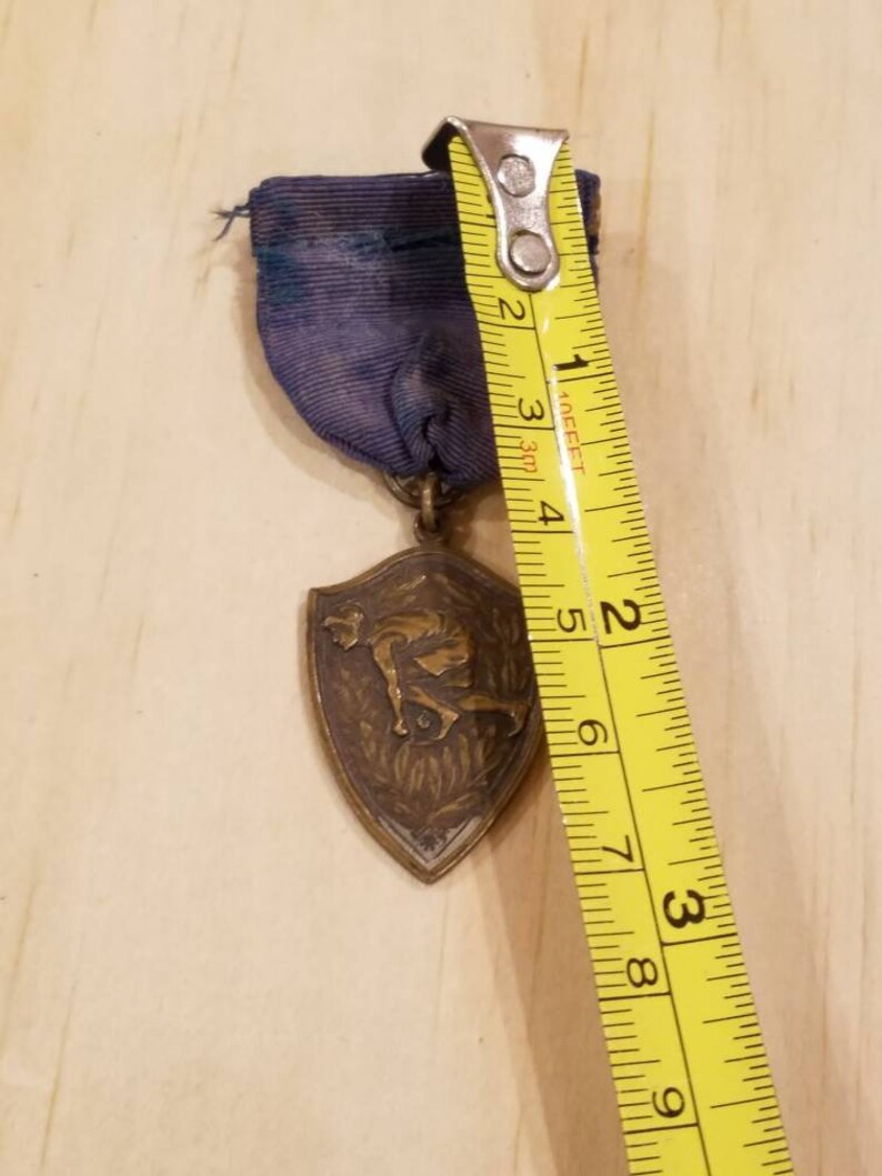 Gold color Vintage track and field medal pin intact blue ribbon Antique sports medal pin with blue ribbon.
