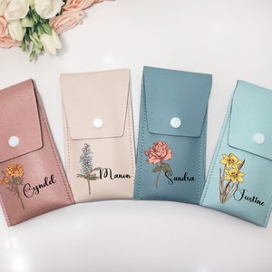 Peut inclure: Quatre étuis de téléphone personnalisés avec des motifs floraux et des noms. Les étuis sont en rose, beige, bleu et bleu clair. Les fleurs sont un souci, une fleur bleue, une rose et une jonquille. Les noms sont Cynddl, Manon, Sandra et Justine.