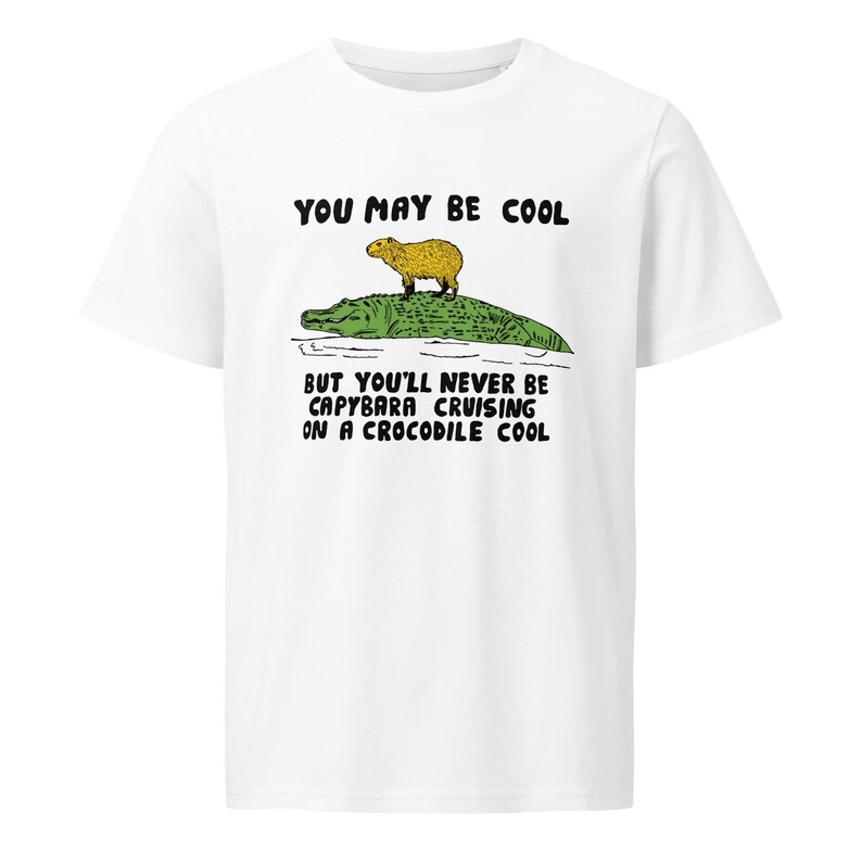 May include: White t-shirt with a graphic of a capybara riding a crocodile. The text "You may be cool but you'll never be capybara cruising on a crocodile cool" is printed on the shirt.