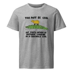 May include: A gray t-shirt with the text "You may be cool but you'll never be capybara cruising on a crocodile cool" and a cartoon image of a capybara riding a crocodile.