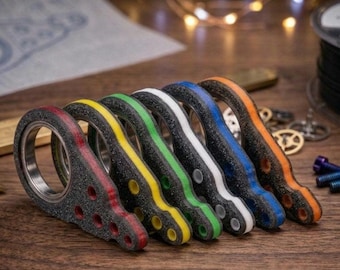 May include: A set of six textured, triangular-shaped finger spinners arranged in a row. Each spinner features a central metal bearing and a distinct coloured edge in red, yellow, green, white, blue, or orange, with three small circular holes.