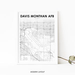 May include: Black and white line art map of Davis Monthan AFB in Arizona. The map shows the layout of the base with roads, buildings, and other features.