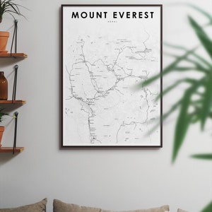 Pu&ograve; includere: Una mappa in bianco e nero del Monte Everest in Nepal, incorniciata da una cornice nera. La mappa mostra la posizione della montagna e l'area circostante, con vari sentieri e punti di riferimento etichettati.
