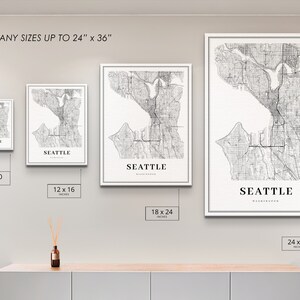 May include: Four different sizes of a black and white map print of Seattle, Washington. The prints are framed in white and are displayed on a light gray wall. The text "PRINT ANY SIZES UP TO 24" x 36"" is at the top of the image. The sizes of the prints are 8 x 10 inches, 12 x 16 inches, 18 x 24 inches, and 24 x 36 inches.