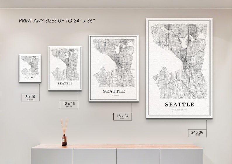 May include: Four different sizes of a black and white map print of Seattle, Washington. The prints are framed in white and are displayed on a light gray wall. The text "PRINT ANY SIZES UP TO 24" x 36"" is at the top of the image. The sizes of the prints are 8 x 10 inches, 12 x 16 inches, 18 x 24 inches, and 24 x 36 inches.