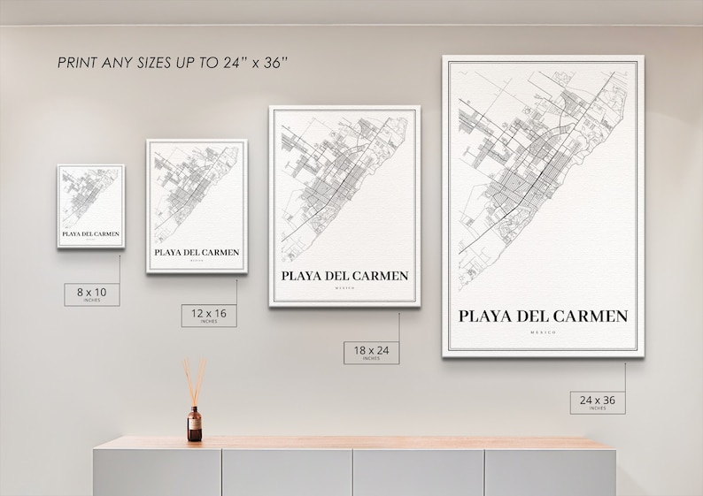 May include: Four different sizes of a black and white map print of Playa del Carmen, Mexico. The prints are framed in a white frame and are displayed on a white wall. The sizes are 8x10 inches, 12x16 inches, 18x24 inches, and 24x36 inches.