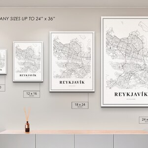 May include: Four different sizes of a black and white map print of Reykjavik, Iceland. The prints are framed in white and are displayed on a white wall. The sizes are 8x10 inches, 12x16 inches, 18x24 inches, and 24x36 inches.