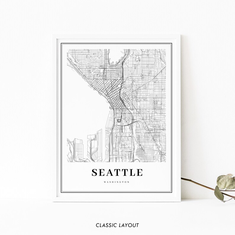 May include: Black and white map print of Seattle, Washington with the city name and state printed below the map. The map shows the streets and roads of the city. The print is framed in a white frame.