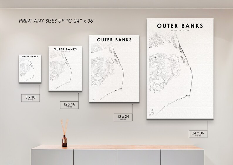 K&ouml;nnte beinhalten: Eine wei&szlig;e Wand mit vier Schwarzwei&szlig;drucken von Karten der Outer Banks, North Carolina. Die Drucke sind in verschiedenen Gr&ouml;&szlig;en: 8x10 Zoll, 12x16 Zoll, 18x24 Zoll und 24x36 Zoll. Der Text "DRUCKEN SIE ALLE GR&Ouml;SSEN BIS ZU 24" x 36" befindet sich oben an der Wand.