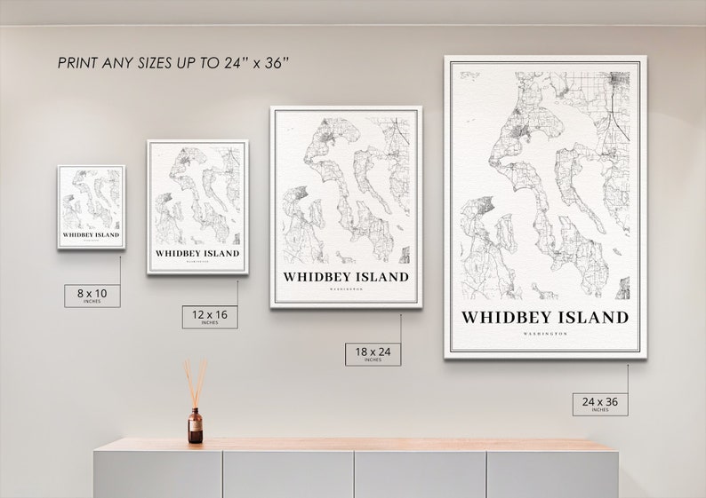 May include: A wall display showing different sizes of a black and white map print of Whidbey Island, Washington. The print sizes are 8x10 inches, 12x16 inches, 18x24 inches, and 24x36 inches.