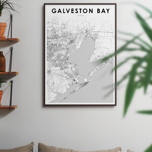 May include: A black and white map print of Galveston Bay, Texas, in a brown frame. The map shows the coastline and surrounding area.