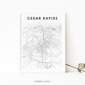 May include: Black and white line art map of Cedar Rapids, Iowa. The map shows the city's streets and waterways. The text "CEDAR RAPIDS" and "IOWA" is at the top of the map. The text "MODERN LAYOUT" is at the bottom of the map.