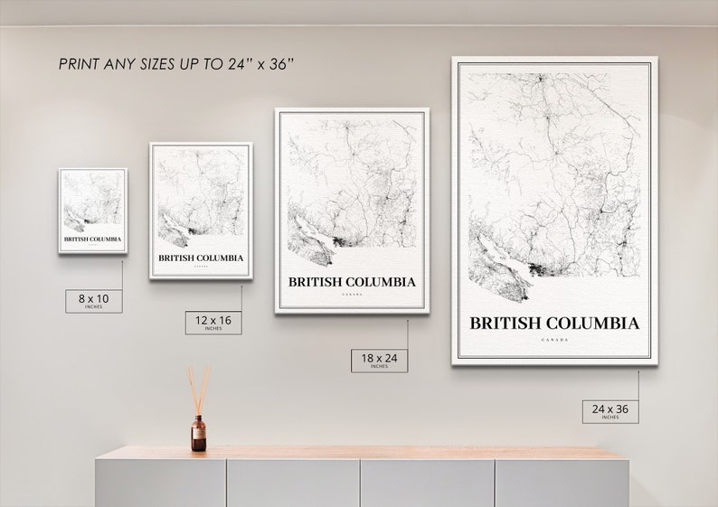 May include: Four different sizes of a black and white map print of British Columbia, Canada. The prints are framed in white and are displayed on a light grey wall. The sizes are 8x10 inches, 12x16 inches, 18x24 inches, and 24x36 inches.