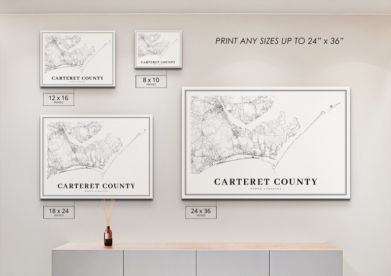 May include: Four framed black and white prints of a map of Carteret County, North Carolina. The prints are displayed on a white wall with a light brown wooden shelf below. The prints are available in four sizes: 8x10 inches, 12x16 inches, 18x24 inches, and 24x36 inches. The text 'PRINT ANY SIZES UP TO 24' x 36' is displayed above the prints.