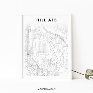 Puede incluir: Un mapa de líneas en blanco y negro de Hill AFB en Utah. El mapa muestra la disposición de la base, incluidos los edificios, las carreteras y las pistas. El texto "HILL AFB" y "UTAH" está impreso en la parte superior del mapa. El texto "MODERN LAYOUT" está impreso en la parte inferior del mapa.