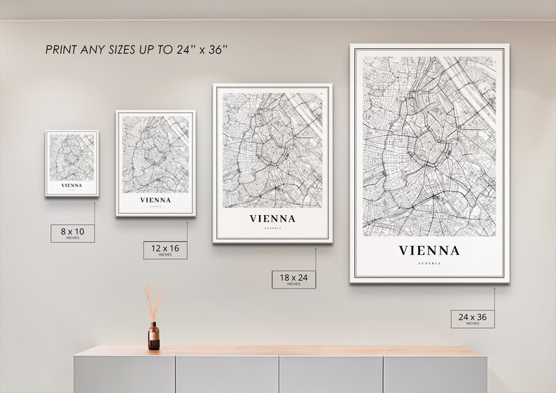 Op de afbeelding: Vier ingelijste zwart-wit kaarten van Wenen, Oostenrijk, die de straten van de stad laten zien. De lijsten zijn wit en de kaarten zijn gedrukt op wit papier. De kaarten worden weergegeven op een witte muur met een houten plank eronder. De kaarten zijn verkrijgbaar in vier formaten: 8x10 inch, 12x16 inch, 18x24 inch en 24x36 inch.